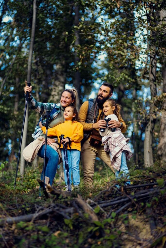 ilustrasi poto suami istri dengan dua anak perempuan sedang berada di gunung