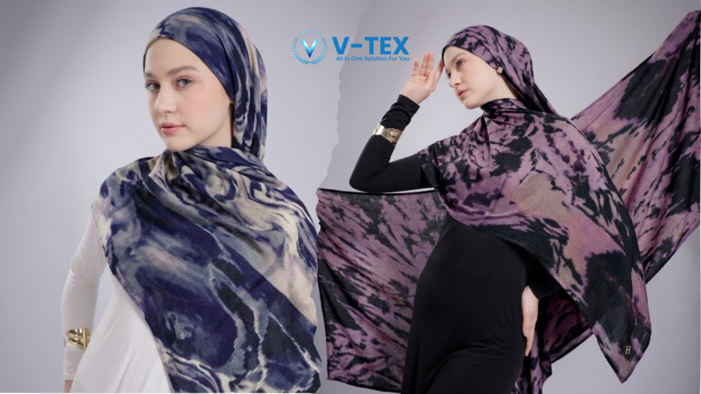 Gambar split-panel yang menampilkan model wanita mengenakan pashmina viscose simple dengan motif tie-dye abstrak dari V-TEX. Sisi kiri menunjukkan model menghadap ke depan dengan pashmina biru tie-dye yang dililitkan sebagai hijab di atas kemeja putih. Sisi kanan menunjukkan model melihat ke atas, mengenakan pashmina hitam dan ungu tie-dye yang dililitkan sebagai hijab di atas gaun hitam. Teknik pelilitan pashmina yang simple dan elegan.